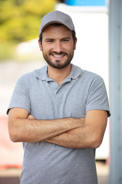 portrait of male worker wearing gret polo shirt and cap
