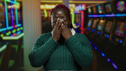 Woman crying in casino surrounded by colorful slot machines, displaying emotions of loss and...