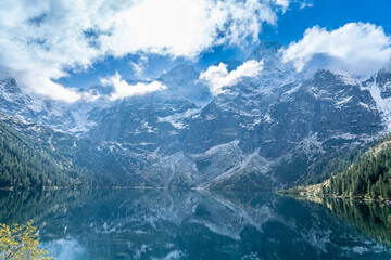 Panoramic View of Morskie Oko Lake and Snowy Tatra Mountains under Dramatic Clouds, Zakopane, Poland © Marcin