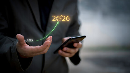 Businessman touching 2026 with arrow target icon, representing new year business goal, strategic planning, vision, annual growth and roadmap for success from 2025 to the future.