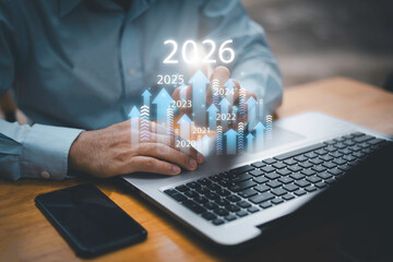 Businessman drawing digital growth arrows and bar graph with 2026 target. Futuristic concept for business goals, technology strategy, data-driven planning, success and innovation.