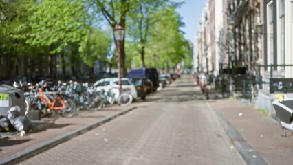 Amsterdam city street with blurred view featuring bicycles and green trees lining a serene urban landscape, capturing the essence of a defocused bokeh cityscape.