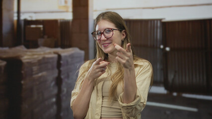 Young blonde woman smiling as she points finger at a building under construction; confidence...