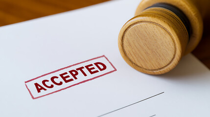 Paper stamped with "ACCEPTED" conveys official approval. The wooden stamp rests on the white document, suggesting validation and formal acceptance.