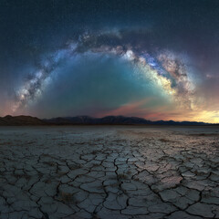 Milky Way over cracked desert landscape