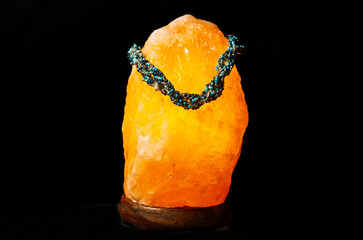 Multi-coloured beaded necklace displayed on a Himalayan salt lamp
