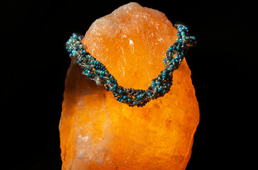 Multi-coloured beaded necklace displayed on a Himalayan salt lamp