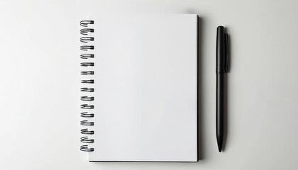 Blank spiral notebook lies next to black pen on clean white surface. Ready for writing, drawing, or planning tasks. Simple setup for creative work or note-taking.