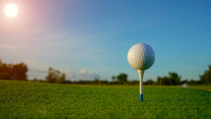 Close-up golf ball on tee with blur green bokeh background.