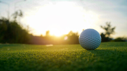 Golf balls on a green lawn in a beautiful golf course with morning sunshine.