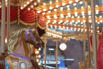 Fototapeta premium Christmas fair carousel, bustling market and illuminated stalls, European holiday magic at night.