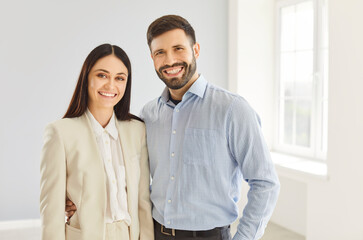 Joyful portrait of a happy married couple standing and smiling together in new home or apartment, celebrating love, family unity, and the happiness of starting a new chapter in life.