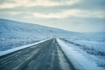 Road trip with empty road with snowy for white environment along the way for travel in iceland.