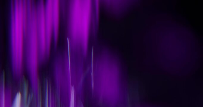 Abstract violet blurred light leaks on dark background with copy space for design. Studio anamorphic lens flare bokeh effect for title or logo display.