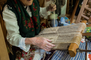 Elderly woman weaving fabric on traditional loom cozy workshop colorful threads