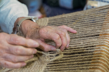 Skilled artisan weaving natural fibers traditional loom intricate patterns