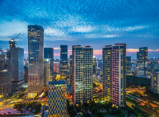 Naklejka premium Modern office buildings and skyscrapers in the financial district of a contemporary city at night in Shenzhen.