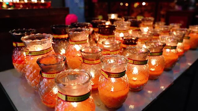 Burning candles in glass pineapple shaped chandeliers in the Chinese temple Malaysia