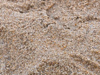 Discover the tiny wonders of the beach with a detailed close-up of sand grains. Each grain reveals a unique texture and color, shaped by nature and time. Perfect for illustrating natural beauty.