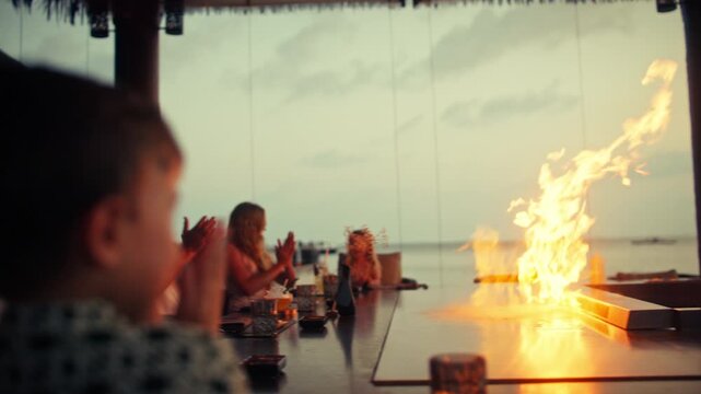 A captivating teppanyaki chef performs a stunning fire show for guests at a tropical resort