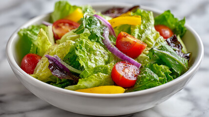 Bowl of fresh vegetable salad on a marble surface.