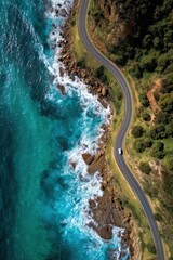 Aerial view of a winding coastal road along rocky cliffs and turquoise ocean