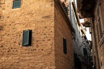 Stone facade with louver shutters in alley