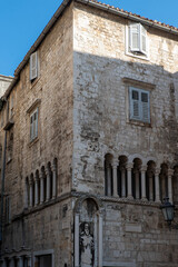 Stone facade with arcade and shutters