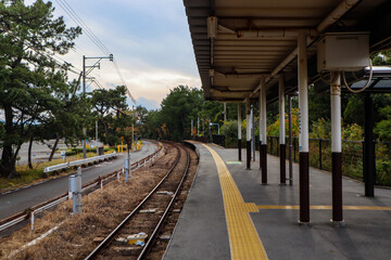 Fototapeta premium Empty Rural Japanese Train Platform and Curved Tracks.