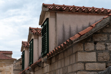 Dormer windows with green shutters, terracotta roof © Sergey