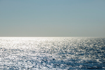 Fototapeta premium Sunset with shining waves and wide open sea view