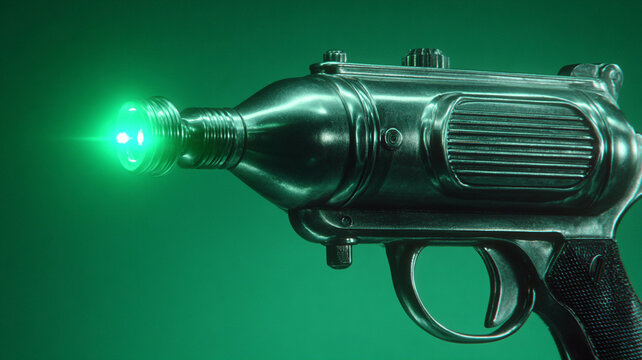 Retro futuristic science fiction raygun weapon firing powerful green laser. vintage toy gun evokes nostalgic and dangerous feeling from classic concepts
