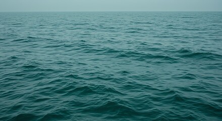 Ocean surface with small waves and hazy horizon