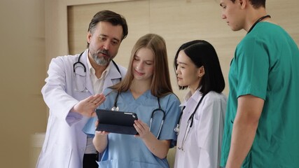 Multiracial group of doctors using tablet to review patient data and plan treatment together, showing teamwork, technology, and collaboration in healthcare. - Powered by Adobe