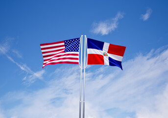 flags of  dominican republic and United States of America over blue sky background.