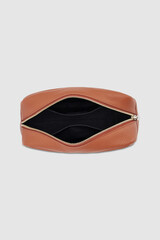 Open brown leather cosmetic bag with gold zipper on gray background