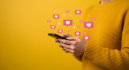 Person using smartphone with social media likes and hearts icons floating above screen on yellow background