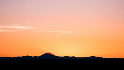 Obraz premium Serene horizon sun setting over rolling hills landscape