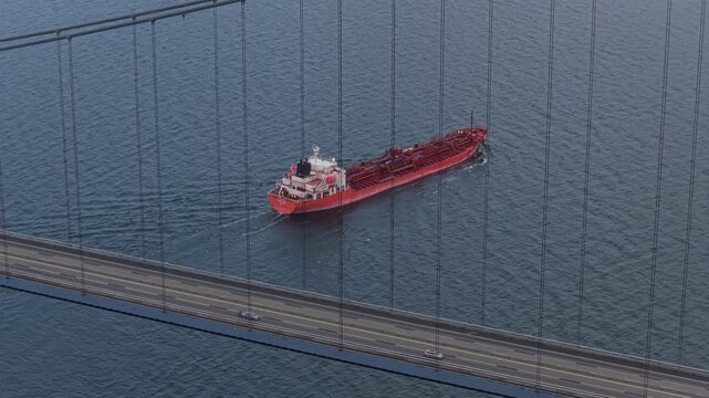Drone perspective of Great Belt Bridge and petroleum tanker.