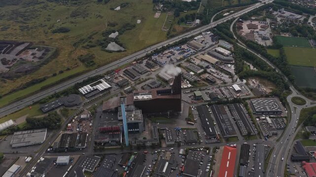 Steam plume above utility plant; energy production captured by drone.