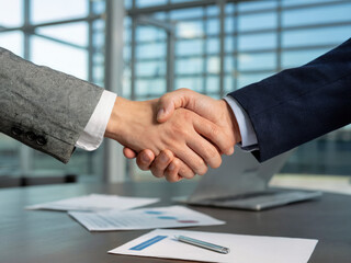 Professional business handshake in modern office building, partnership agreement and corporate success concept, businessmen shaking hands for teamwork and cooperation