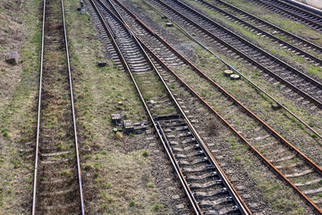 Obraz premium Railroad tracks at or near a train station. Suitable for articles about transportation, nature photography, or travel.