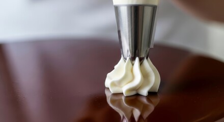 Pastry chef decorating cake with white cream using piping bag. Close-up of dessert decoration. Food styling for bakery and confectionary creation.
