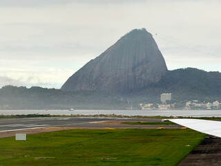 Santos Dumont Airport with aircraft wing and runway with Corcovado mountain in the background on cloudy spring day at city of Rio de Janeiro. Photo taken October 11th, 2025, Rio de Janeiro, Brazil.
