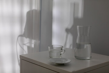 An Elegant Still Life of a Water Pitcher and a Glass on a Beautiful Table Surface