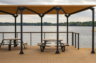 Waterfront terrace with round picnic table and canopy on a calm lake