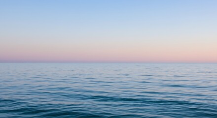Obraz premium A realistic and modern background with calm sea under a pastel sky with gentle waves reflecting the soft light of the horizon at sunset.