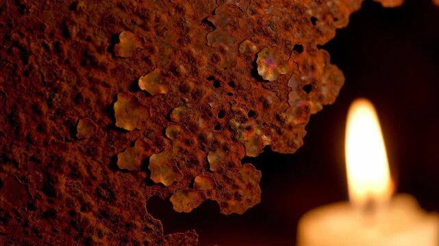 Candle light and rusted metal surface, soft focus background