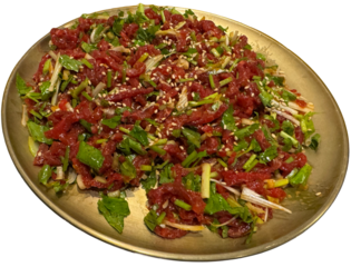 Isolated Korean yukhoe dish with sesame and green herbs on gold plate