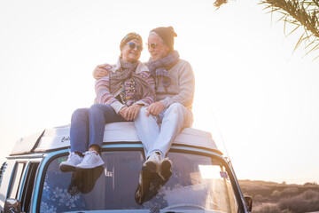 Senior couple standing next to a vintage camper van during a road trip, smiling and in love, concept of active lifestyle, freedom, travel, romance, adventure, eternal love, age is just a number
